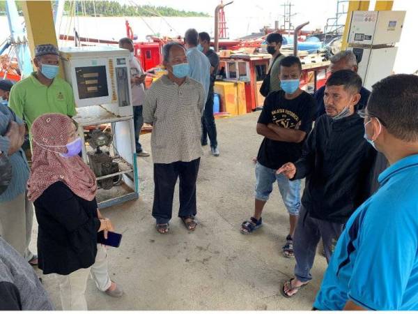 Nik Amran (dua dari kanan) bercerita mengenai kejadian kepada mereka yang hadir di Jeti Lembaga Kemajuan Ikan Malaysia (LKIM) di Kuala Besar di sini.