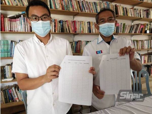 Cheng Chung (kiri) dan Zuraidi menunjukkan borang petisyen yang akan diedarkan bagi mengumpulkan tanda tangan penduduk mendesak tindakan segera kerajaan negeri menaiktaraf sistem penyaluran bekalan air bersih di Kuantan.