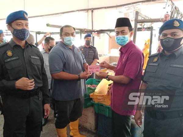 Mohd Zawawi (dua dari kanan) bersama pegawai KPDNHEP ketika melakukan tinjauan Skim Harga Maksimum Musim Perayaan Hari Raya Puasa (SHMMP) 2021 di Pasar Besar Meru pada Selasa.