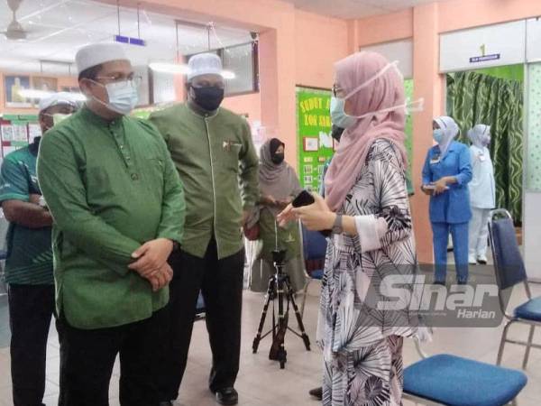 Mohd Akmal (kiri) ketika mengadakan lawatan ke Klinik Kesihatan Selama pada Selasa.