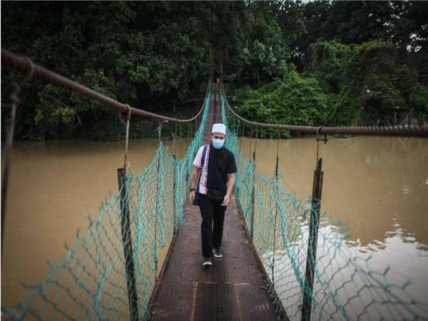 Ebit ketika meninjau keadaan jambatan tempat dua beradik itu terjatuh sebelum dihanyutkan arus di Kampung Rekoh. Foto: Facebook Ebit Lew