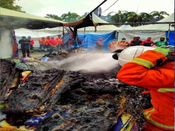 Kebakaran yang menyebabkan kanopi yang menjual karpet dan pakaian raya musnah. - Foto JBPM