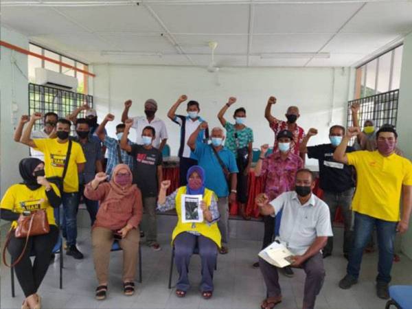 Hamidah (duduk, dua dari kanan) bersama sebahagian penduduk yang mengadu masalah bau busuk daripada ladang ternakan babi berhampiran ketika mengadakan sesi pertemuan di Dewan Orang Ramai Kampung Bunga Tanjung di sini pada Jumaat.