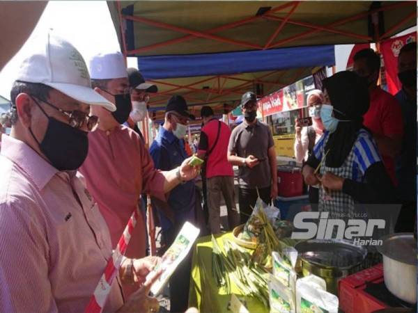 Sulaiman dan Ahmad (kiri) ketika melawat gerai jualan di Pasar Tani FAMA sempena program Jelajah Ramadan 2021di Pasar Tani Masjid Tanah di sini, pada Sabtu.