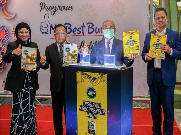 Ronald (dua dari kanan) menunjukkan buku Inspirasi Agropreneur Muda selepas melancarkannya dalam Program My Best Buy Aidilfitri di kementerian itu pada Isnin.