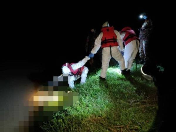 Pasukan bomba dan penyelamat memakai pakaian pelindungan diri (PPE) untuk menaikkan mayat wanita yang ditemui terapung di tepi Sungai Rambai, Bestari Jaya, Kuala Selangor pada Jumaat.