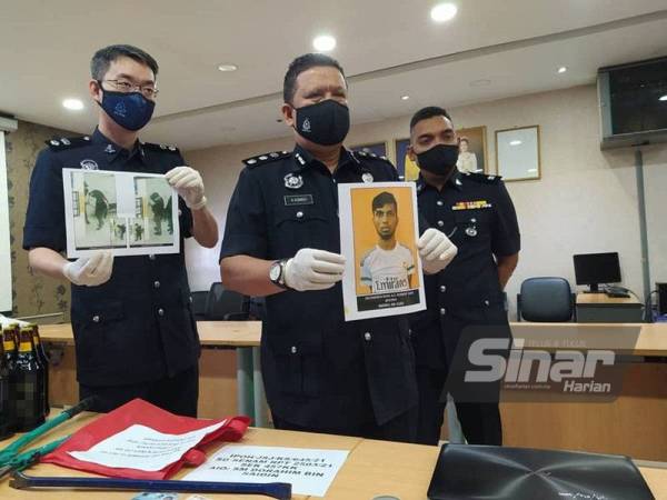 A Asmadi (tengah) menunjukkan wajah individu yang sedang dikesan oleh pihak polis bagi membantu siasatan berkaitan Geng Dobi Tiguan yang berjaya ditumpaskan ketika sidang akhbar di IPD Ipoh pada Selasa.