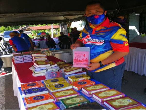 Muhammad Hydier menunjukkan al-Quran yang bakal diagihkan ke setiap surau yang terpilih di kawasan Sepang pada Selasa.