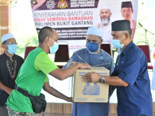 Syed Abu Hussin (tengah) menyampaikan bantuan asnaf sempena Ramadan di Bukit Gantang.