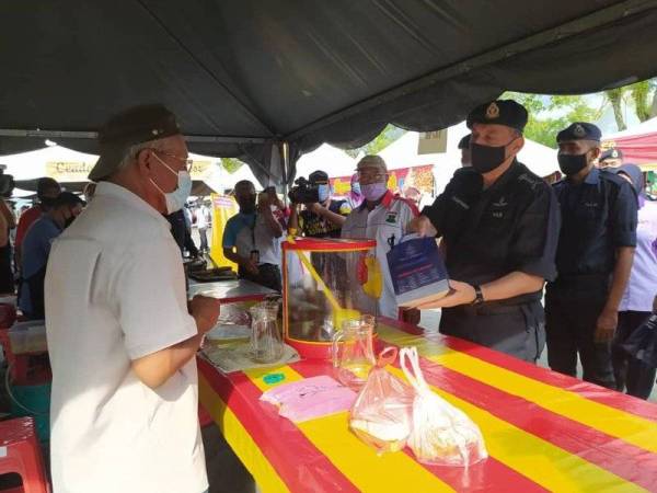 Mior Faridalathrash (kanan) bertemu dengan peniaga ketika melakukan pemantauan SOP di Bazar Ramadan Stadium Perak, Ipoh pada Selasa.