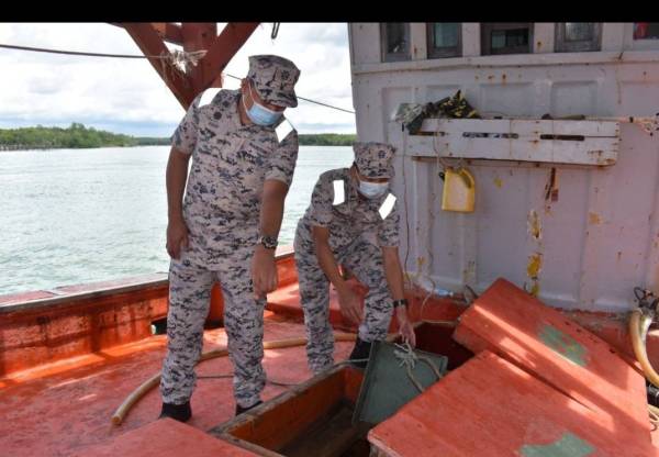 Rashidilhadi (kiri) menunjukkan sebahagian daripada barang rampasan susulan penahanan bot nelayan Vietnam di perairan Kuala Kemaman pada Rabu. - Foto: Ihsan Maritim Malaysia Zon Kemaman