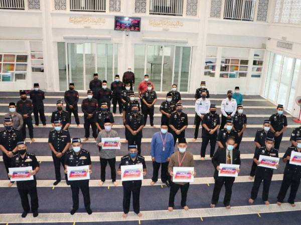  Ayob (depan, tiga dari kiri) dan peserta memegang plakad World #QuranHour selepas menjayakan program World #QuranHour di Masjid Tunku Laksamana Abdul Jalil, IPK Johor. -Foto: Polis Johor