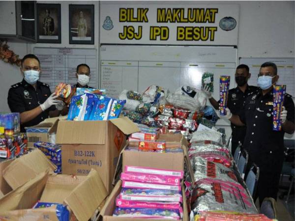 Abdul Rozak (kanan) menunjukkan pelbagai jenis mercun dan bunga api yang dirampas bernilai RM 80,000 pada sidang media di IPD Besut, pada Rabu. Foto: Bernama 