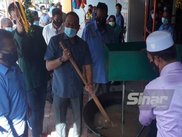 Awang (tiga kiri) mengacau dodol sebagai simbolik perasmian Program Jualan Pra-Syawal Pasar Tani Kekal (PTK) Guar Chempedak di Yan pada Sabtu.