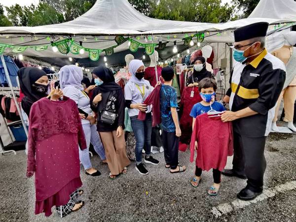 Anak-anak Khalis dibantu memilih baju raya