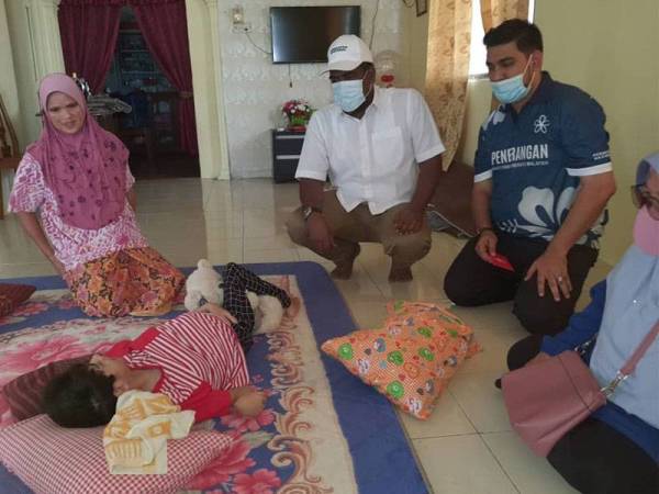 Kader Maideen Hussan (dua dari kiri) ketika menziarahi Nurul Akma Abdul Rashid yang terlantar di rumah di Kampung Kurnia Jaya Tambahan, Kamunting, Taiping. 