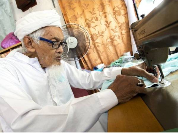 Che Hamat tekun menyiapkan tempahan baju Melayu pelanggannya ketika ditemui di kedai jahitnya Harison Style di Kampung Kubang Cherang, Wakaf Che Yeh.  - Foto Bernama