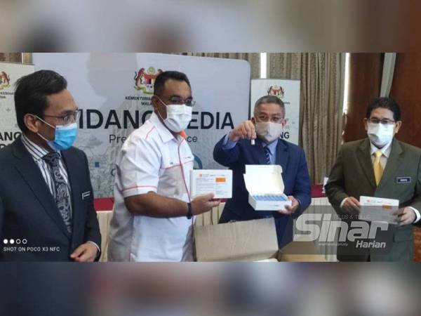 Dr Adham (dua dari kanan) bersama Pengarah Urusan Pharmaniaga LifeSience, Datuk Zulkarnain Md Eusope (dua dari kiri) menunjukkan vaksin Sinovac yang dibotolkan oleh syarikat itu di negara ini pada sidang akhbar majlis penyerahan pengeluaran pertama vaksin Covid-19 di Putrajaya pada Selasa.