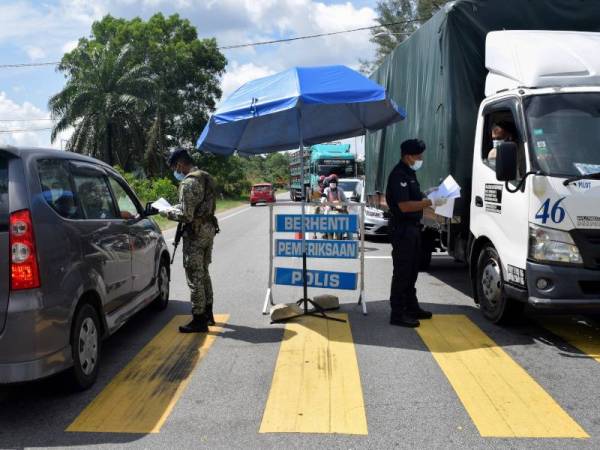 Anggota polis yang bertugas di sekatan jalan raya sepanjang musim Aidilfitri dan tempoh Perintah Kawalan Pergerakan (PKP) perlu berhati-hati kerana terdedah dengan virus Covid-19. - Foto Bernama