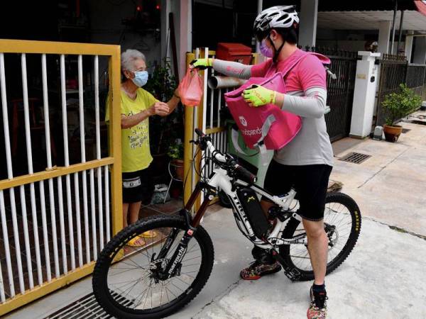 Ahli Fisiologi di sebuah hospital swasta, Thor Al Wayne,26, menggunakan basikal bukit atau 'mountain bike' milik rakannya dan menempuh perjalanan antara 10 KM hingga 15 KM setiap hari sehingga tengah malam untuk membuat penghantaran makanan di kawasan George Town dan Bayan Lepas. - Foto Bernama