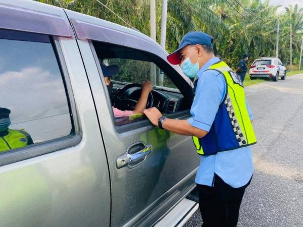 Barudin turun memeriksa kenderaan yang melalui Jalan Gelung Pepuyu- Beruas. Foto: Ihsan PDRM