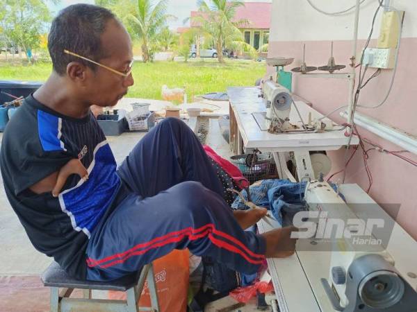 Pok Su Mie melakukan kerja dengan kaki bermula dari mengukur, memotong sehinggalah menjahit pakaian yang diminta oleh pelanggan.