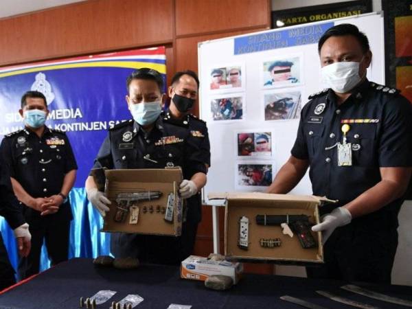 Hazani menunjukkan pistol dan parang yang digunakan kumpulan pengganas Abu Sayaf dalam kejadian berbalas tembakan dengan anggota polis di sebuah kawasan setinggan di Beaufort pada 11.27 pagi semalam. - Foto Bernama