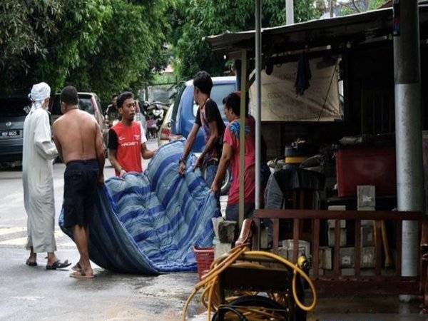 Penduduk di Taman Rambai Indah, Bukit Rambai membersihkan rumah selepas kawasan itu terjejas akibat banjir pada Isnin.