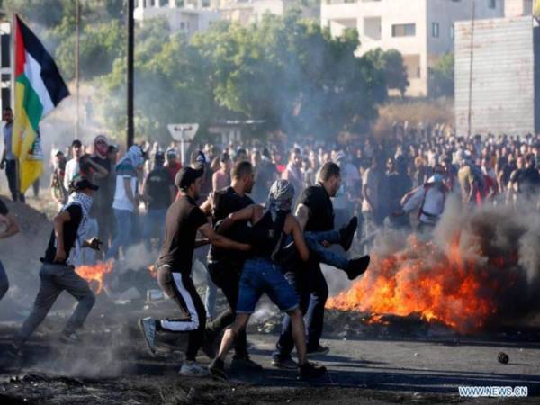 Beberapa penduduk Palestin mengusung seorang lelaki yang cedera akibat ditembak oleh tentera Israel di sebuah pusat pemeriksaan dekat bandar Nablus, Tebing Barat pada Selasa. - Foto Xinhua