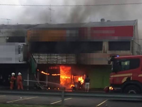 Anggota bomba sedang memadam kebakaran sebuah kedai alat ganti kereta di Pekan Tanjong Karang di sini pada Rabu.