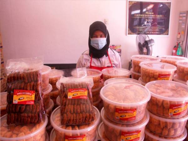 Nor Azizah, menunjukkan dua produk yang dikeluarkan oleh syarikatnya Nab Food Industries Sdn Bhd, di premisnya di No.5, Jalan Raja Syed Thauphy 2, Pusat Bandar Baru, Bagan Serai, pada Rabu. - Foto Bernama