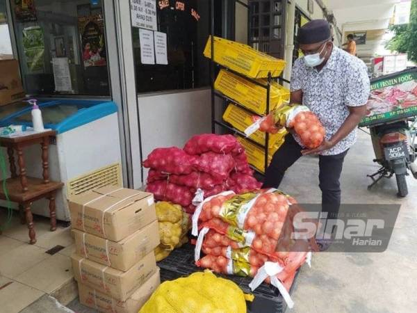 Mohamed Arib memeriksa stok barangan di kedainya di Tasek bagi memastikan ia sentiasa mencukupi sepanjang tempoh PKPD yang akan bermula pada Sabtu di Mukim Hulu Kinta.