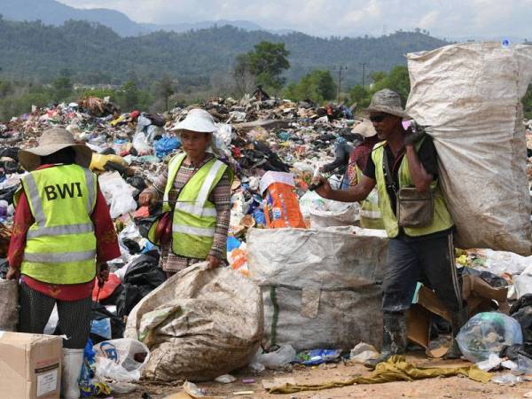 Golongan pengutip sampah mencari barang buangan yang boleh dijual di Tapak Pelupusan Sampah Kayu Madang. Foto Bernama