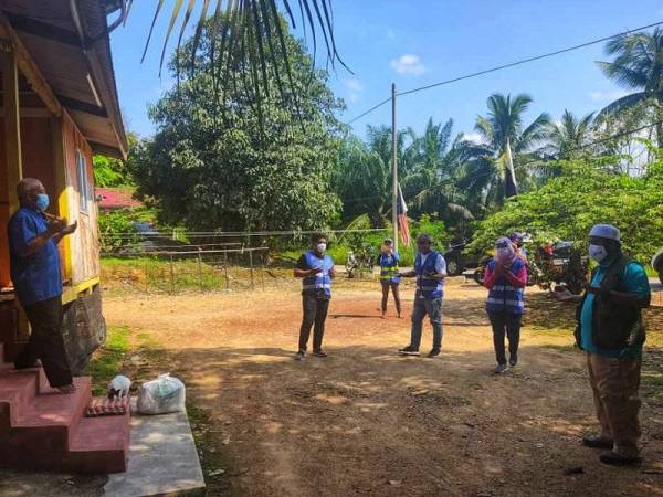 Mohd Zakhwan (kanan) turun padang mengagihkan sumbangan kepada penduduk di Perumahan Banjir Kuala Teh, Jerantut, Ahad.