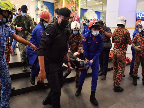 Antara penumpang yang mengalami kecederaan apabila dua tren Transit Aliran Ringan (LRT) terlibat dalam kemalangan berhampiran stesen KLCC dibawa keluar untuk dihantar ke hospital malam Selasa. - Foto Bernama
