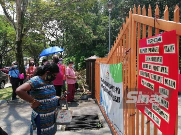 Orang awam yang menunggu di luar pagar menunggu giliran mereka dibenarkan masuk.