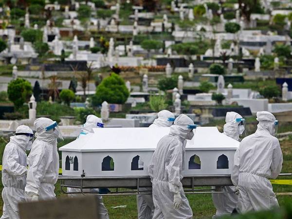 Pasukan Tajhiz JHEAINS yang lengkap memakai PPE mengusung jenazah pesakit Covid-19 bagi urusan pengebumian di Makam Tuan Haji Said, pada Selasa. - Foto bernama