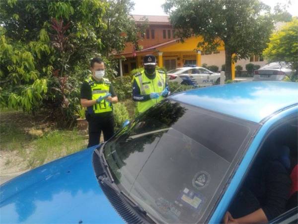 Ahmad Shukri Mat Akhir (kanan) melakukan pemeriksaan 'snap check' di Kampung Alor Ganu pada Rabu.