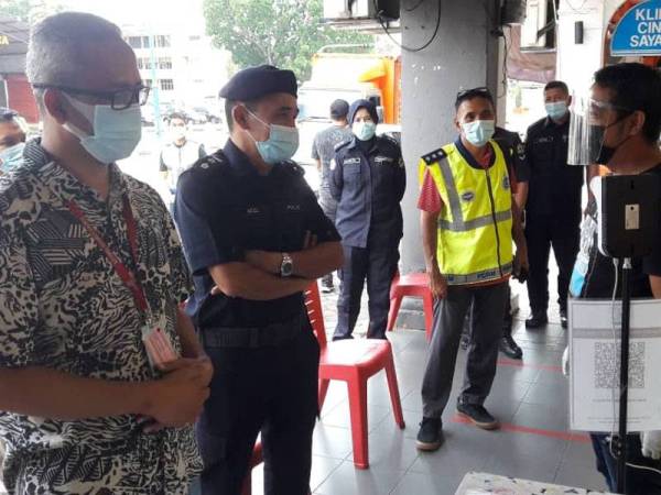 Mohd Zawawi (kiri) dan Adzli (dua kiri) melaksanakan pemantauan dan penguatkuasaan di sekitar Sungai Petani pada Rabu.