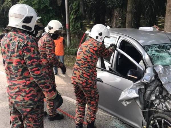 Anggota bomba mengeluarkan mayat seorang lelaki yang tersepit dalam Proton Exora dalam kemalangan di Simpang Renggam, Kluang pada Khamis.