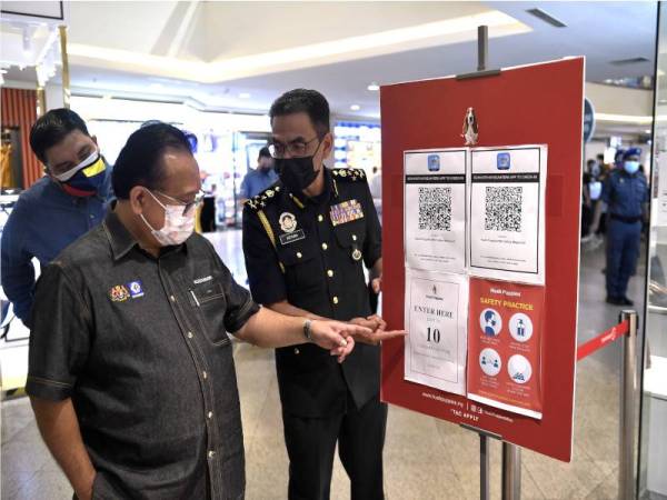 Alexander (dua, kiri) serta Azman ketika meninjau operasi pematuhan prosedur operasi standard (SOP) di Midvalley Megamall, pada Jumaat. - Foto Bernama