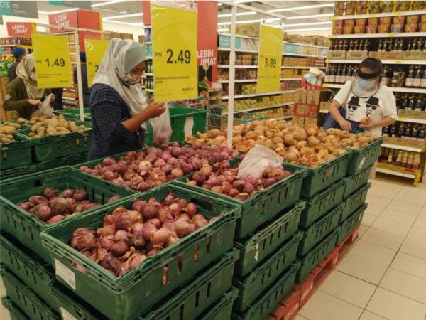 Pelanggan di sebuah pasar raya di Johor Bahru sedang memilih bawang dan kentang, pada Sabtu.