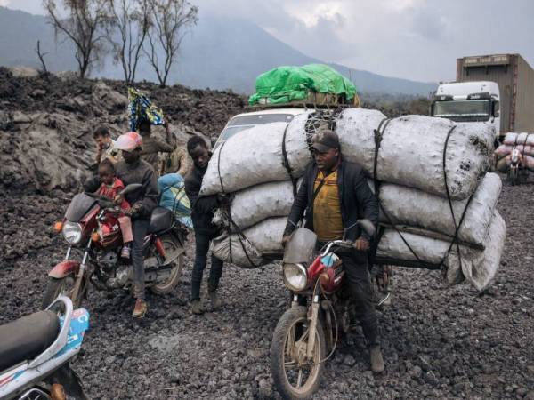 Penduduk meredah jalan yang diselaputi lava beku di kawasan kejiranan utara Goma selepas letusan Nyiragongo pada minggu lalu. - Foto AFP