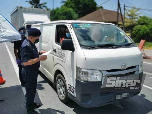 Abdul Rahim memeriksa kebenaran rentas daerah seorang pemandu yang mahu ke Kuala Terengganu ketika membuat tinjauan di SJR Padang Midin pada Ahad.