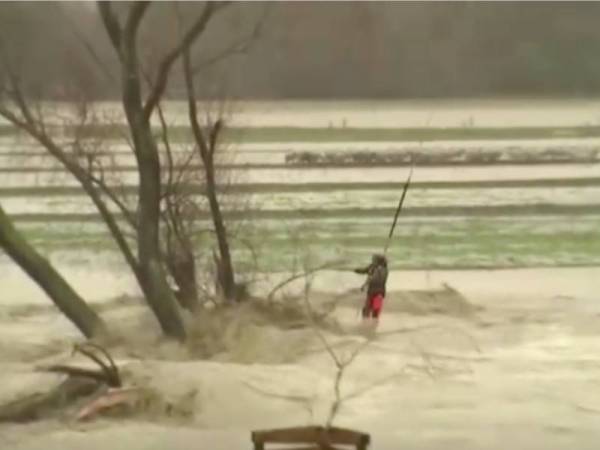 Tangkap layar video menunjukkan seorang lelaki diselamatkan oleh helikopter dari kawasan banjir di Canterbury pada Ahad. - Foto Reuters