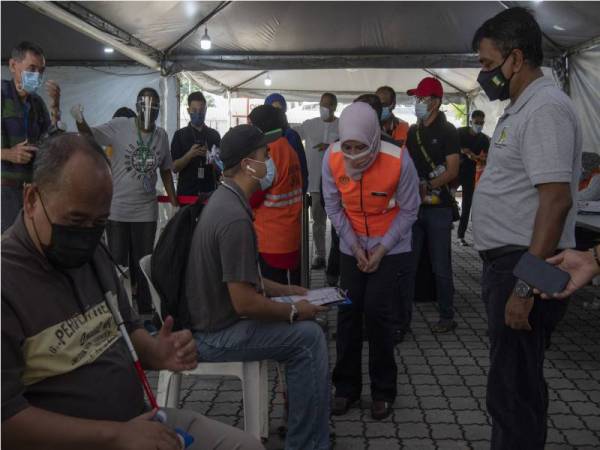 Rina (tiga, kanan) beramah mesra dengan OKU pada Program Imunisasi Kebangsaan Untuk Komuniti OKU Penglihatan di Bangunan Persatuan Bagi Orang Buta Malaysia (MAB), pada Jumaat. - Foto Bernama