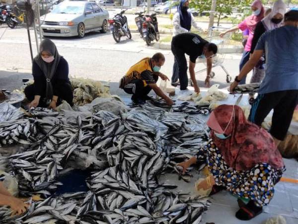 JPKK sedang membungkus ikan untuk diagihkan kepada penerima.