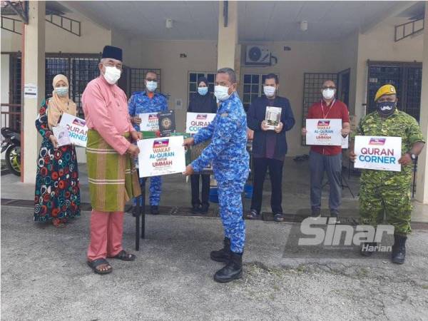 Hashim (kiri) menyerahkan al-Quran wakaf kepada wakil pengurusan PKRC Politeknik Port Dickson pada Jumaat.