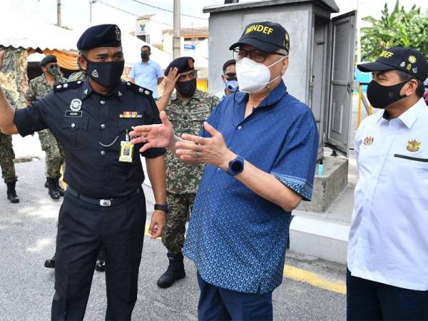 Ismail Sabri (dua dari kanan) mendengar penerangan daripada Ketua Polis Daerah Wangsa Maju, Superintendan Ashari Abu Samah ketika membuat lawatan ke sekatan jalan raya di Jalan Ampang pada Sabtu. - Bernama