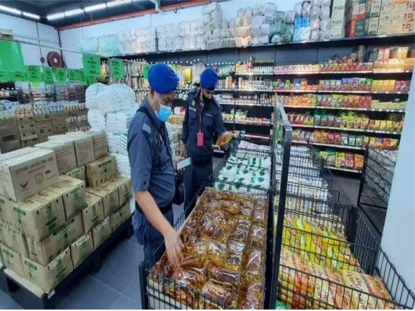 Pegawai penguatkuasa KPDNHEP Pahang melakukan pemeriksaan di sebuah pasar raya bagi memastikan barangan keperluan termasuk minyak masak dalam pasaran di negeri ini sentiasa mencukupi. - Foto KPDNHEP Pahang